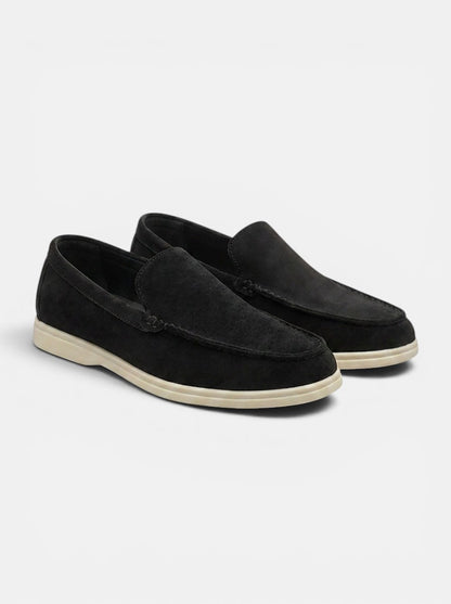 Men's black faux suede slip-on loafers with a cream rubber sole. Casual flats with moccasin construction.