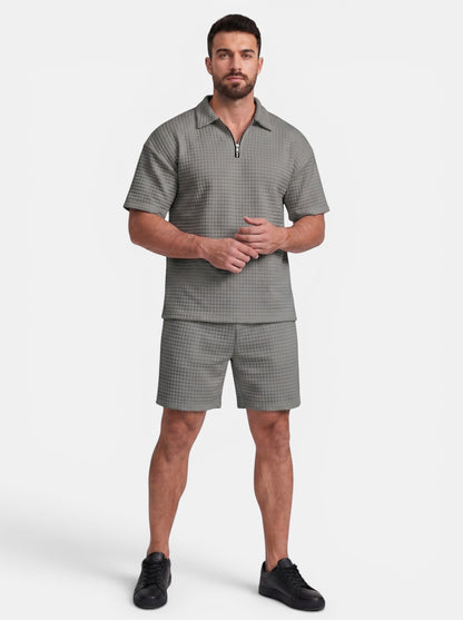 Men's grey quilted polyester short-sleeve polo shirt and shorts set with quarter-zip closure.