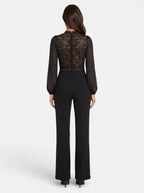 Venatte black crochet lace mesh jumpsuit with long sheer sleeves and flared legs. Elegant evening wear.