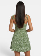 Venatte green floral mini sundress with spaghetti straps and tie details. Lightweight polyester blend.