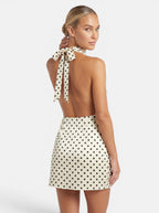 Venatte women's cream and black polka dot halter mini dress with a backless design and tie closure.