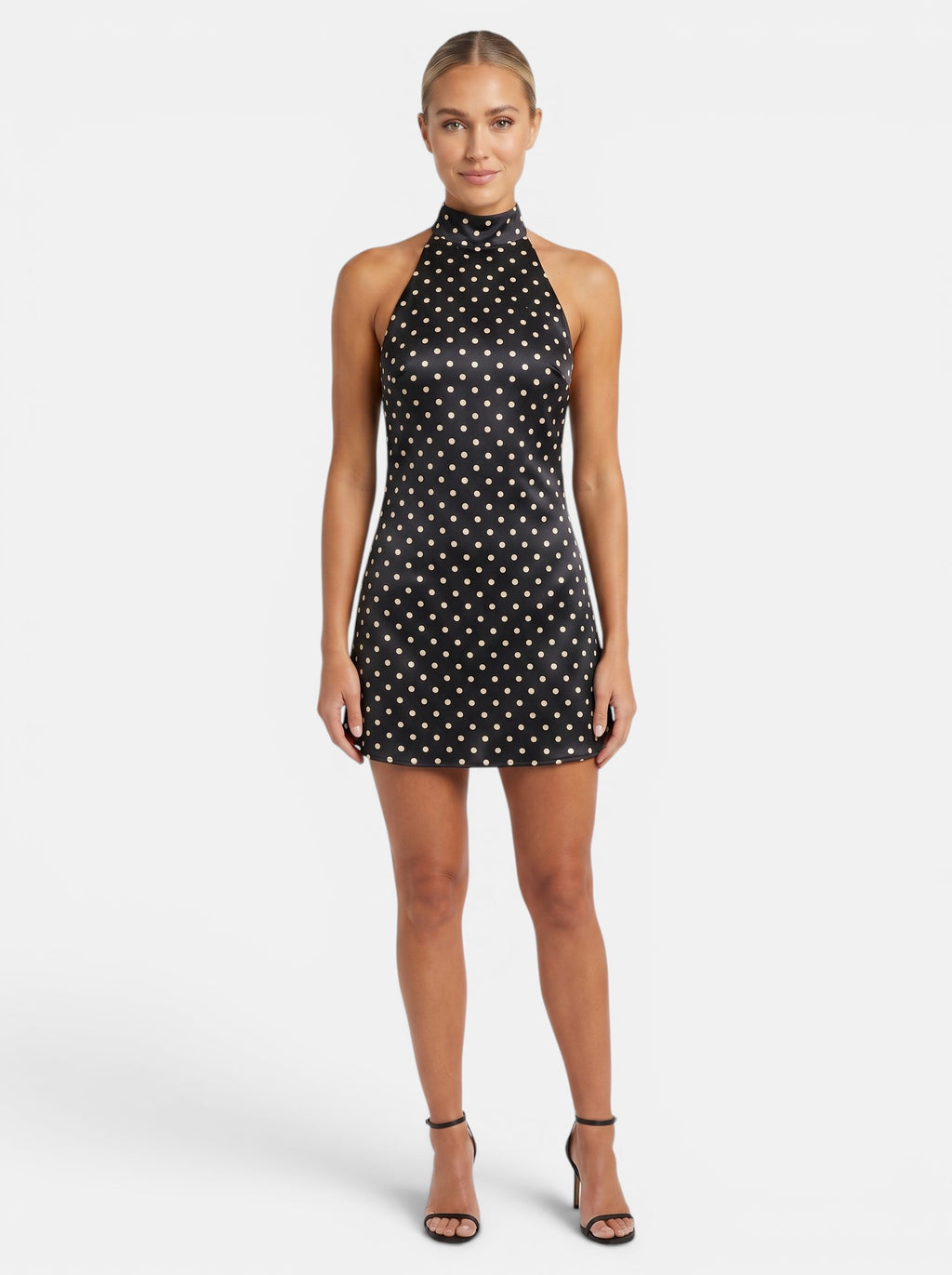 Venatte black polka dot halter mini dress with backless design and lace-up back. Polyester and elastane blend.