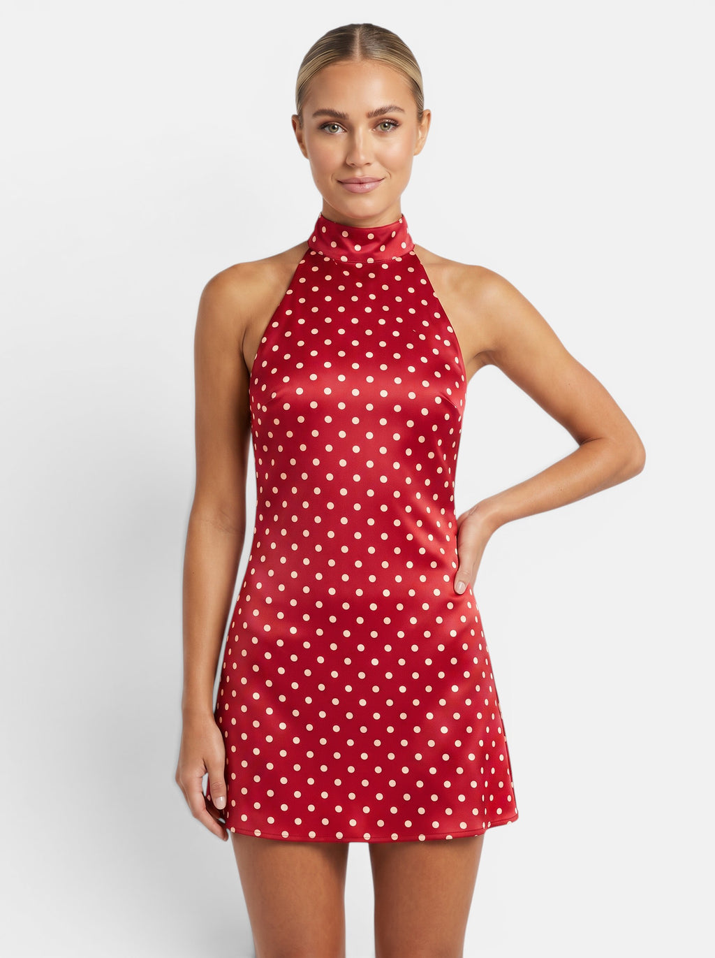 Venatte red polka dot halter mini dress with backless design and lace-up back. Polyester and elastane blend.