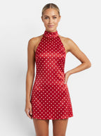 Venatte red polka dot halter mini dress with backless design and lace-up back. Polyester and elastane blend.