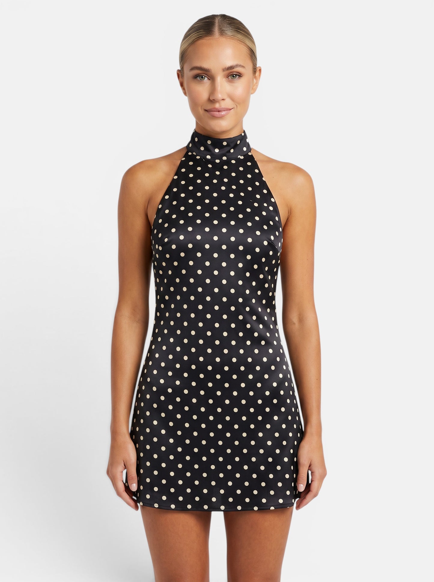 Women's black and cream polka dot halter mini dress with backless lace-up detail and sleeveless cut.