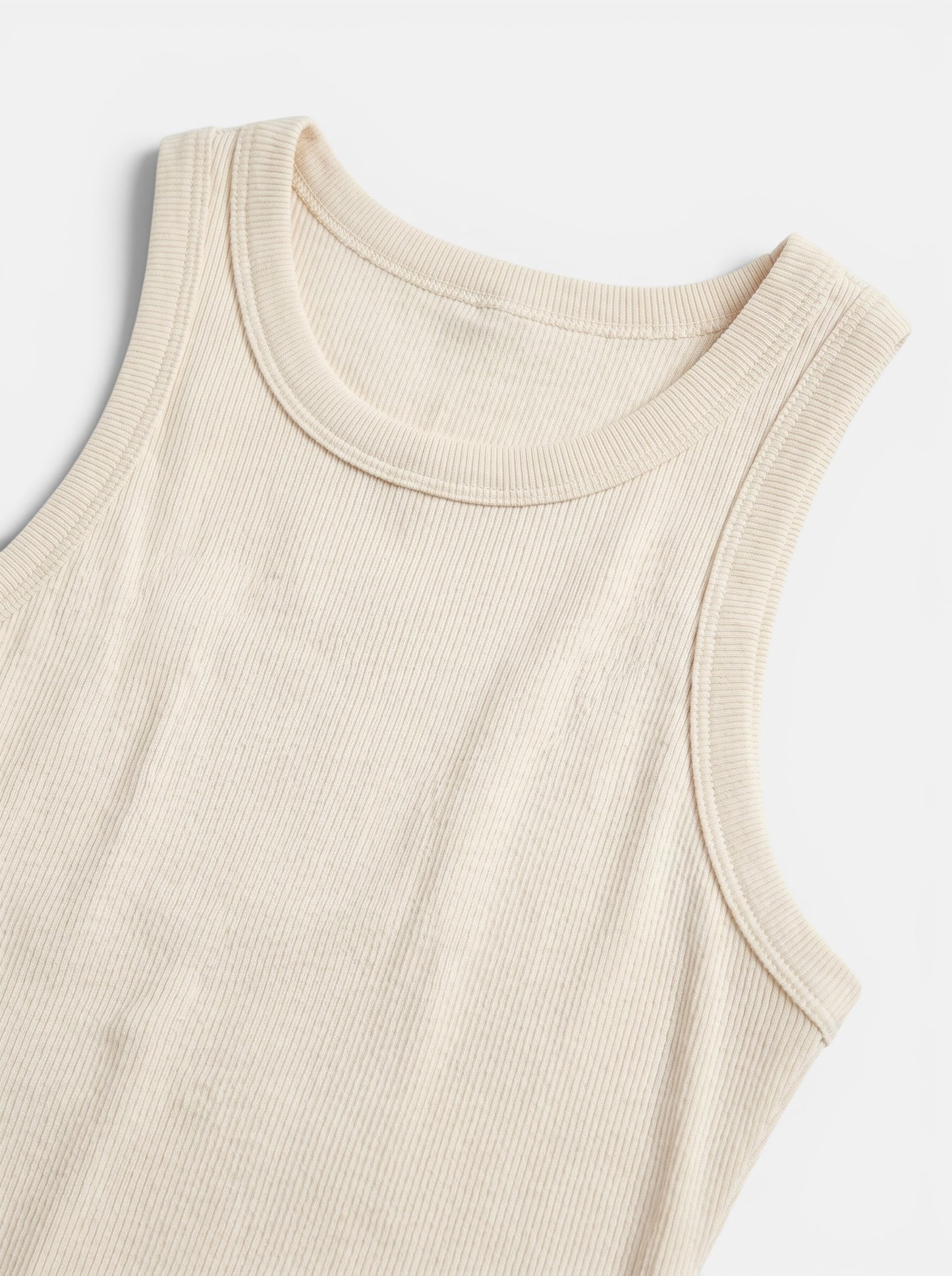 Women's cream ribbed bodycon mini dress, sleeveless, made from a soft polyester blend with stretch.